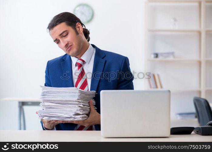 The young male businessman sitting in the office. Young male businessman sitting in the office