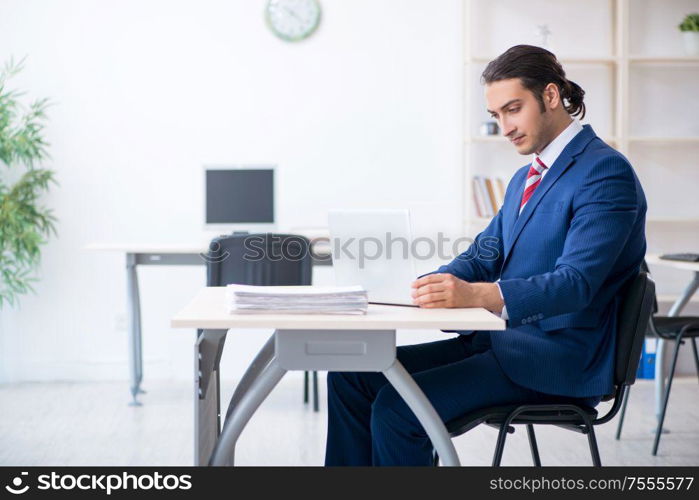 The young male businessman sitting in the office. Young male businessman sitting in the office