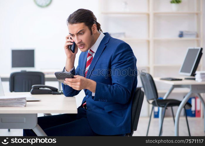 The young male businessman sitting in the office. Young male businessman sitting in the office