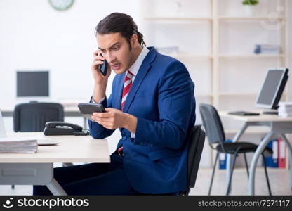 The young male businessman sitting in the office. Young male businessman sitting in the office