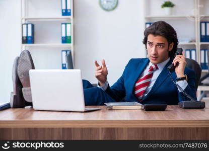 The young male businessman working in the office. Young male businessman working in the office