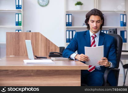 The young male businessman working in the office. Young male businessman working in the office