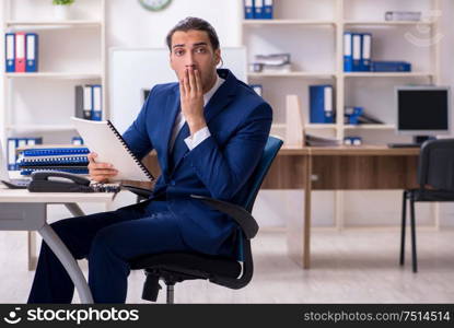 The young male businessman working in the office. Young male businessman working in the office