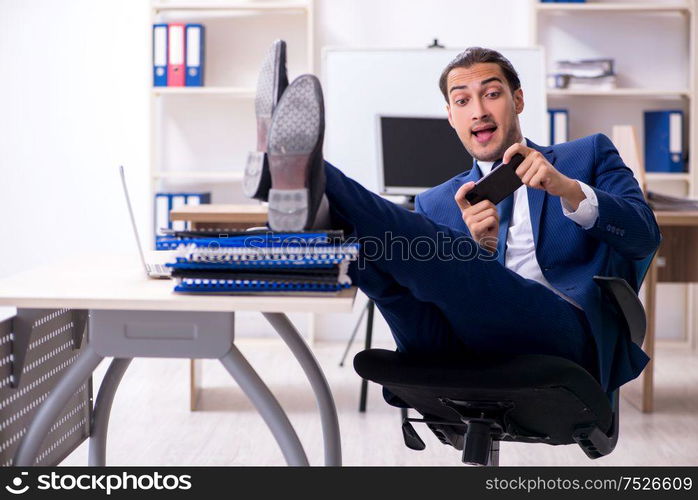 The young male businessman working in the office. Young male businessman working in the office