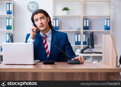 The young male businessman working in the office. Young male businessman working in the office