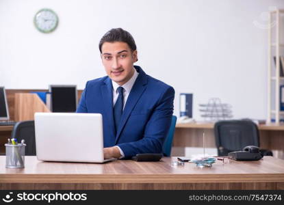 The young male businessman working in the office. Young male businessman working in the office