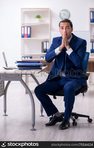 The young male businessman working in the office. Young male businessman working in the office