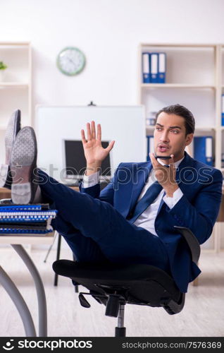 The young male businessman working in the office. Young male businessman working in the office