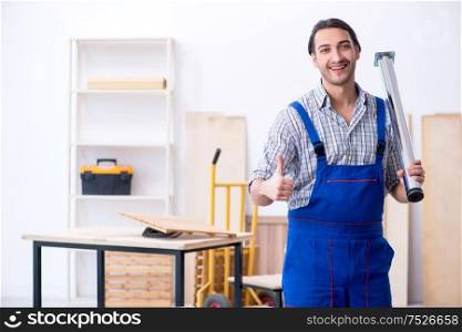 The young male carpenter working indoors. Young male carpenter working indoors