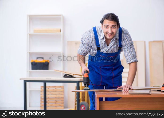 The young male carpenter working indoors. Young male carpenter working indoors