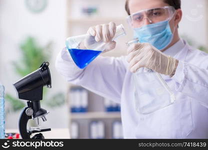 The young male chemist experimenting in lab. Young male chemist experimenting in lab