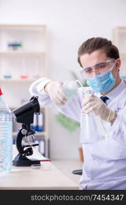 The young male chemist experimenting in lab. Young male chemist experimenting in lab