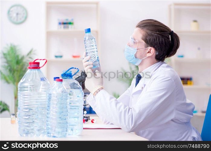 The young male chemist experimenting in lab. Young male chemist experimenting in lab