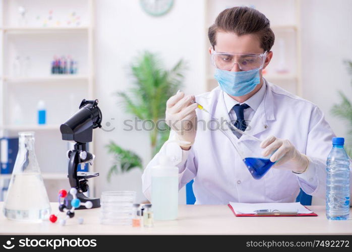 The young male chemist experimenting in lab. Young male chemist experimenting in lab