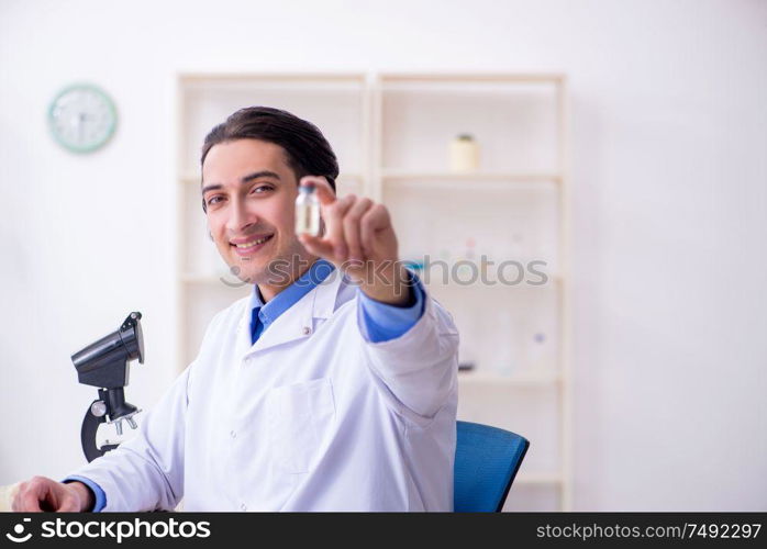 The young male chemist experimenting in lab. Young male chemist experimenting in lab