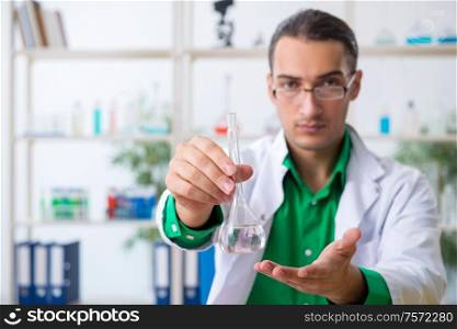 The young male chemist teacher in the lab. Young male chemist teacher in the lab
