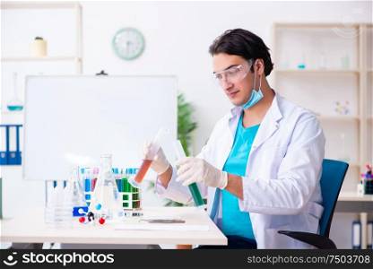 The young male chemist working in the lab. Young male chemist working in the lab