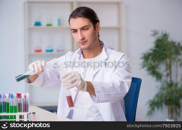 The young male chemist working in the lab. Young male chemist working in the lab