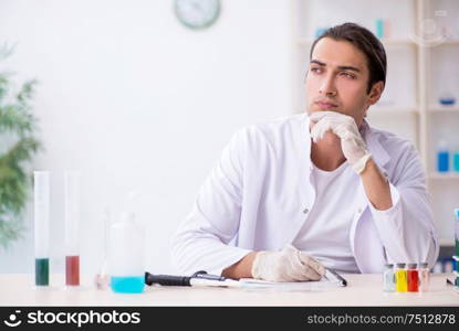 The young male chemist working in the lab. Young male chemist working in the lab