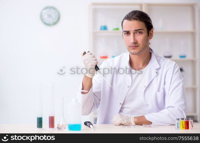 The young male chemist working in the lab. Young male chemist working in the lab