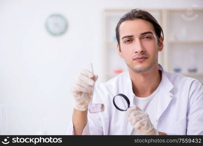 The young male chemist working in the lab. Young male chemist working in the lab