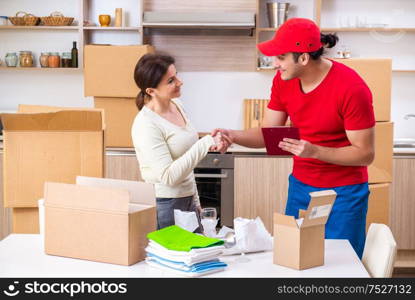 The young male contractor and female customer in moving concept. Young male contractor and female customer in moving concept