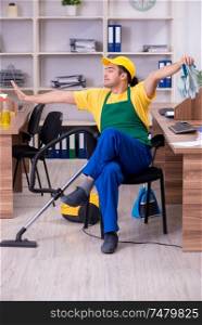 The young male contractor cleaning the office . Young male contractor cleaning the office
