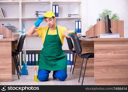 The young male contractor cleaning the office. Young male contractor cleaning the office