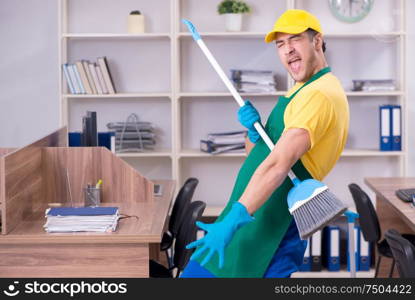 The young male contractor cleaning the office. Young male contractor cleaning the office