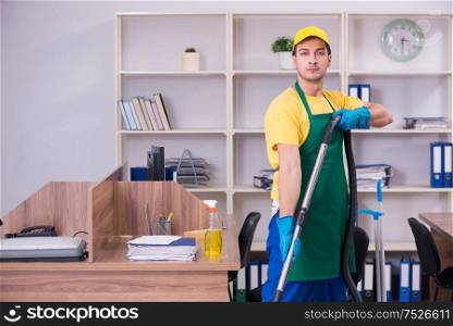The young male contractor cleaning the office. Young male contractor cleaning the office