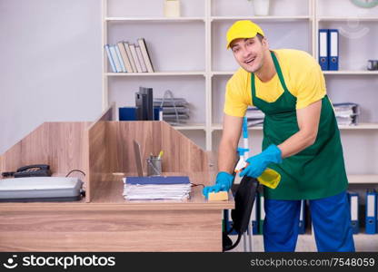 The young male contractor cleaning the office. Young male contractor cleaning the office