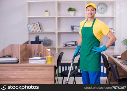 The young male contractor cleaning the office. Young male contractor cleaning the office