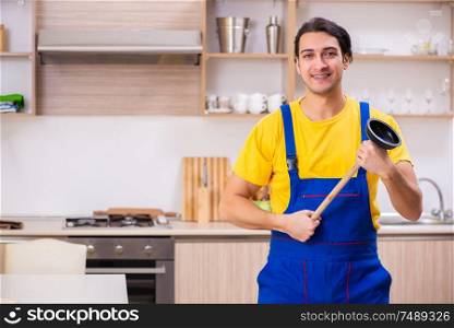 The young male contractor repairing tap at home . Young male contractor repairing tap at home