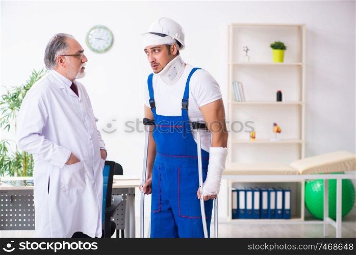 The young male contractor visiting old doctor . Young male contractor visiting old doctor 