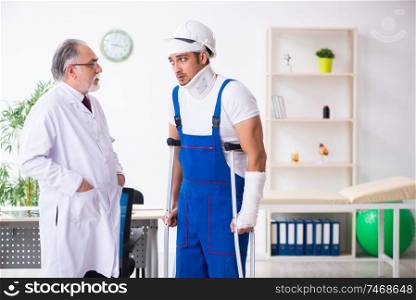 The young male contractor visiting old doctor . Young male contractor visiting old doctor 