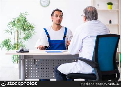 The young male contractor visiting old doctor . Young male contractor visiting old doctor