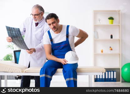 The young male contractor visiting old doctor . Young male contractor visiting old doctor