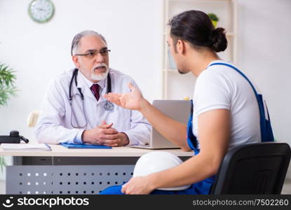 The young male contractor visiting old doctor. Young male contractor visiting old doctor