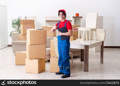 The young male contractor with boxes working indoors . Young male contractor with boxes working indoors 