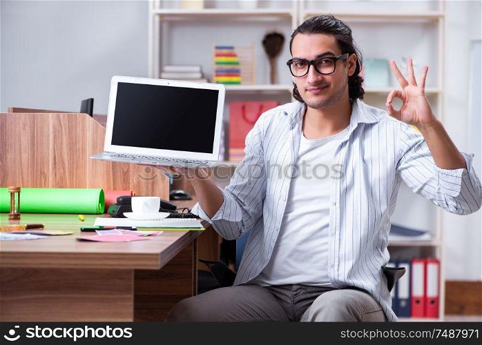 The young male designer working in the office . Young male designer working in the office