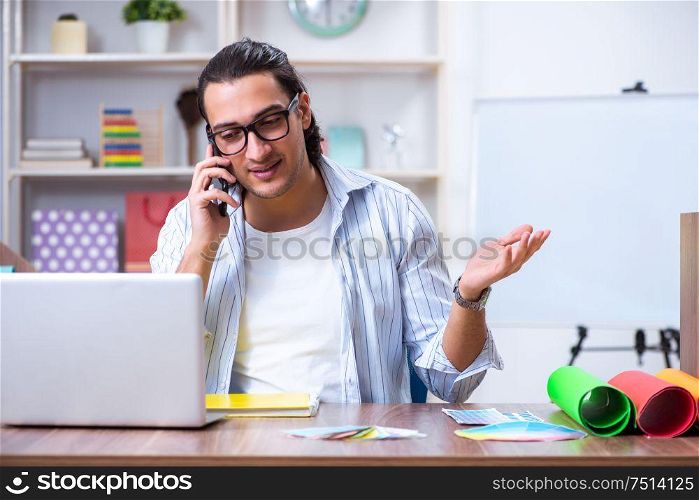 The young male designer working in the office. Young male designer working in the office