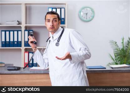 The young male doctor at the reception in the hospital. Young male doctor at the reception in the hospital