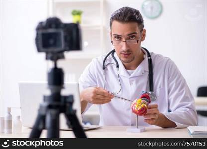 The young male doctor cardiologist recording video for his blog. Young male doctor cardiologist recording video for his blog