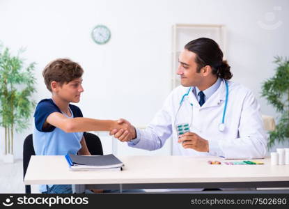 The young male doctor examining boy in the clinic. Young male doctor examining boy in the clinic