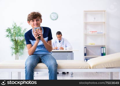 The young male doctor examining boy in the clinic. Young male doctor examining boy in the clinic