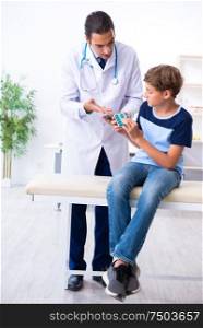 The young male doctor examining boy in the clinic. Young male doctor examining boy in the clinic
