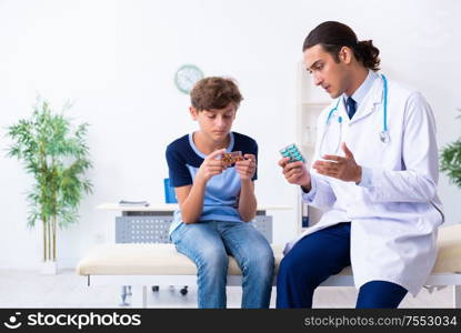 The young male doctor examining boy in the clinic. Young male doctor examining boy in the clinic