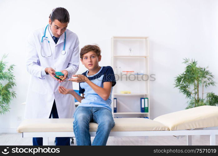 The young male doctor examining boy in the clinic. Young male doctor examining boy in the clinic