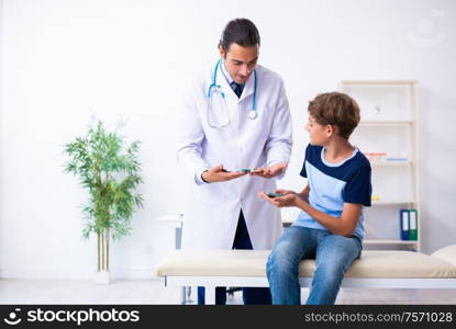 The young male doctor examining boy in the clinic. Young male doctor examining boy in the clinic