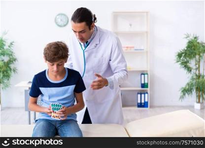 The young male doctor examining boy in the clinic. Young male doctor examining boy in the clinic